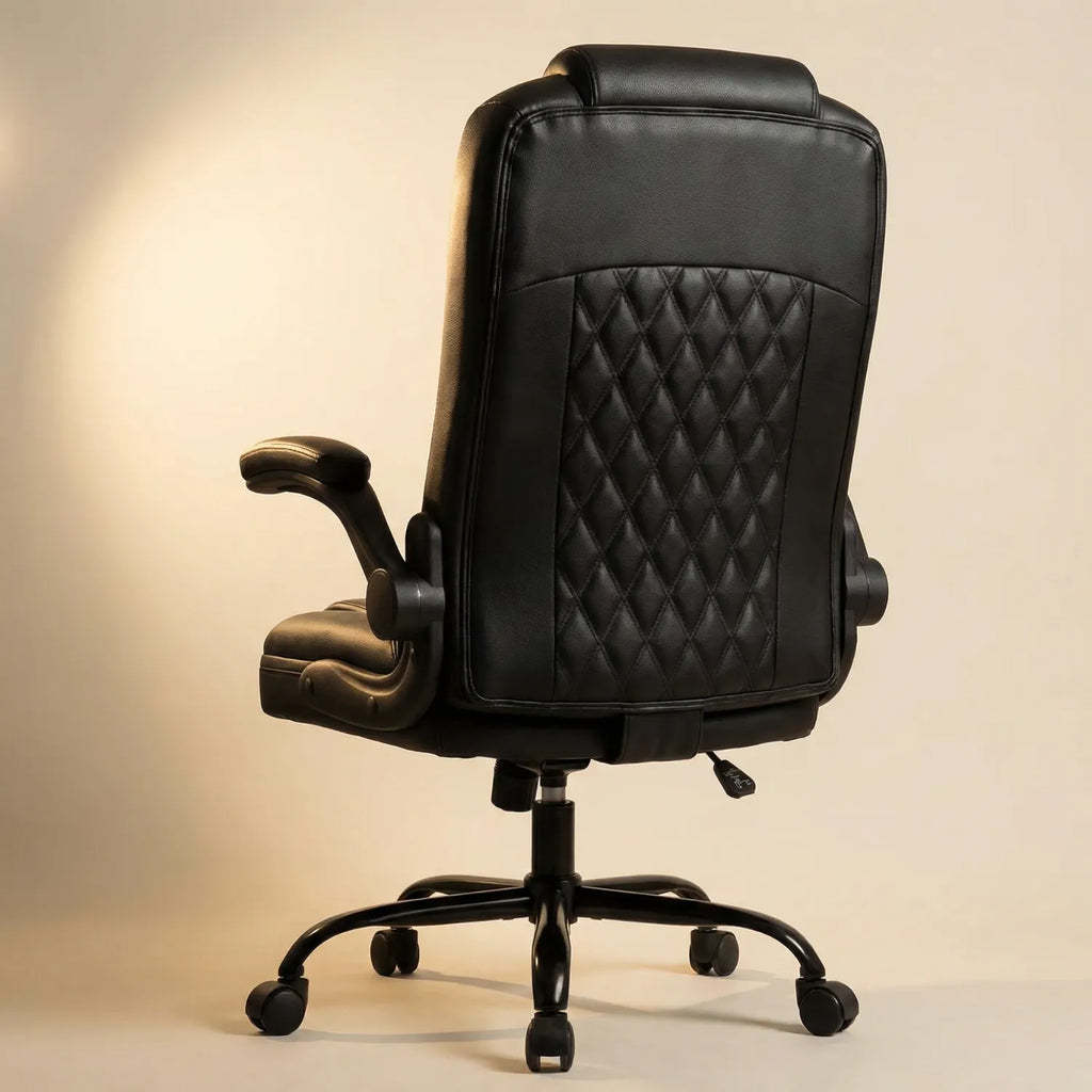 Vue arrière District 19 Chaise de Bureau Cuir Noir Élite avec capitonnage losanges et accoudoirs rabattables, éclairage studio ambre fond beige chaud